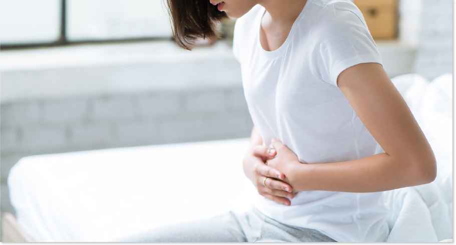 お腹を押さえる女性の写真